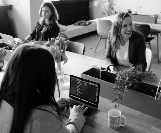 Three girls working in a clean an modern office.